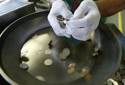 Blank nickel coins being added to machine