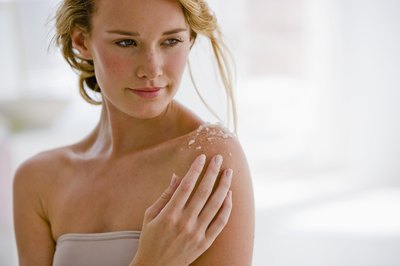 Woman rubbing cream on skin