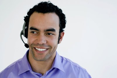 Close-up of a computer technician speaking into a headset.