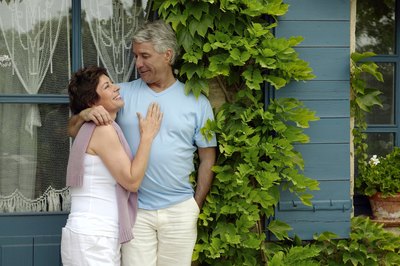 Couple hugging outside home