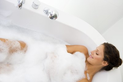 woman relaxing muscles in warm bath