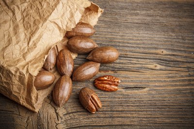 Pecans spilling out of a paper bag.