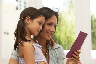 Mother reading card next to daughter