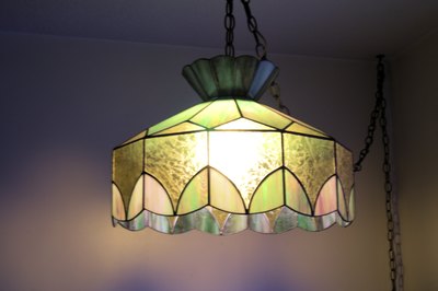 Colourful glass light shade hanging from ceiling.