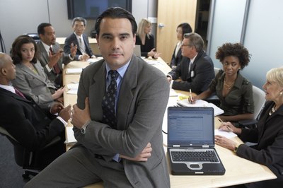 Man sitting at head of table during business meeting.