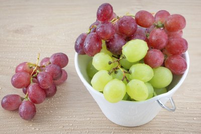 A small bowl of red and green grapes.