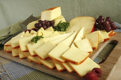 A cheese platter with a few grapes