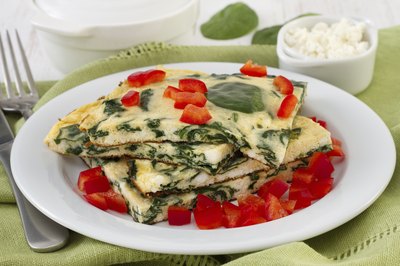 Close-up of a spinach omelet with diced red peppers