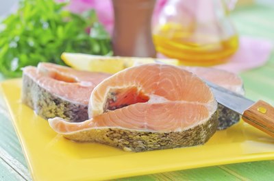 Two pieces of raw salmon on plate in kitchen
