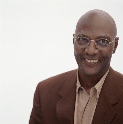 Shaved head male with eyeglasses.