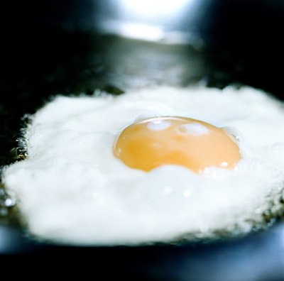 An egg being fried in a pan.