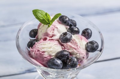 A bowl of ice cream with blueberries.