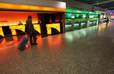 Traveler walks near car rental counters inside airport