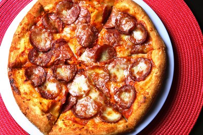 Eating greasy food such as pizza may cause excess stomach acid.