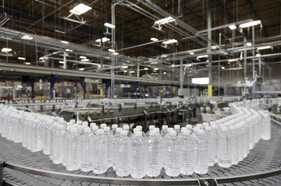 Factory line of water bottles on conveyor belt.