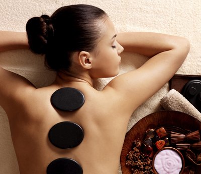 Woman receives stone massage at spa