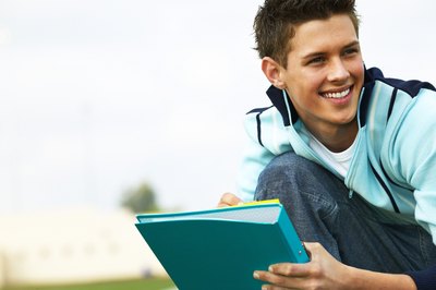 Teenage boy smiling with notebook