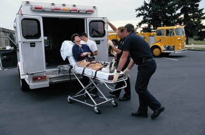 woman getting wheeled into ambulance