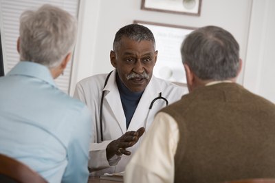 Doctor talking with mature couple.