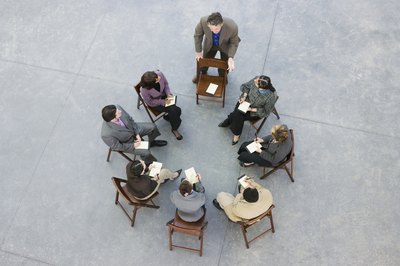 Adults playing musical chairs and gathering