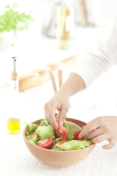 Close-up of woman preparing a salad.