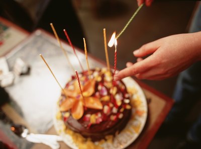 Woman lighting candles on cake