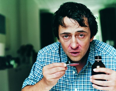 Man taking cough syrup