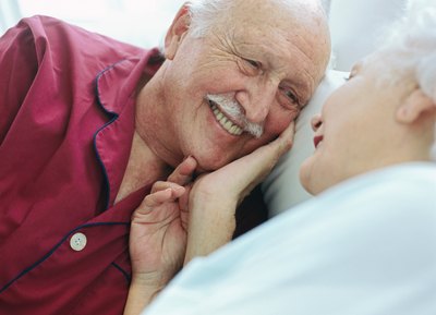 Smiling senior couple in bedroom.