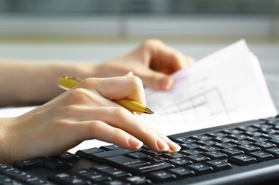 A close-up of a woman doing financial paperwork.