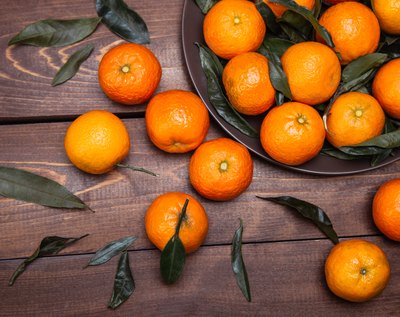 Tangerines in a bowl and on a wood table