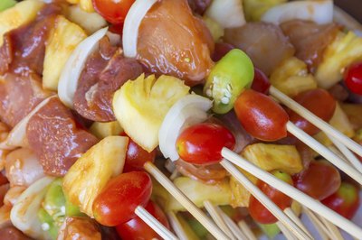 Prepared chicken sticks with pineapple, tomatoes and other vegetables.