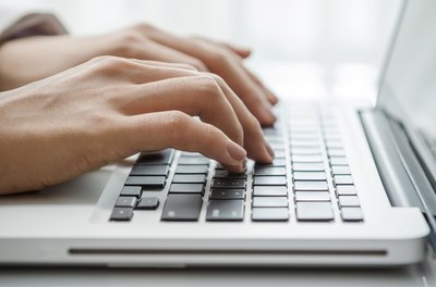 Woman writing on laptop