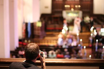 Photographer sets up shot from the balcony of a church