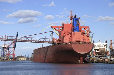 A large oil tanker departs a shipyard.