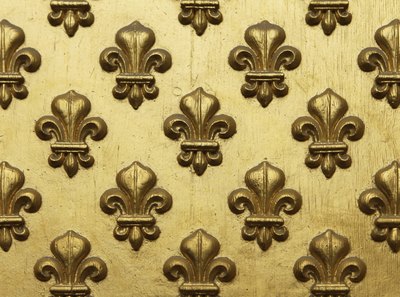 Fleur-de-lis painted gold which are part of a entrance panel to a Paris building