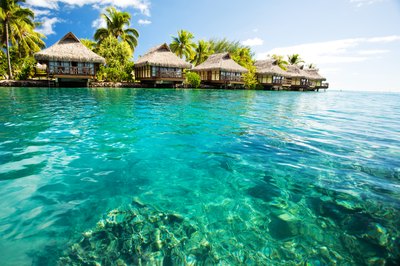 Water bungalows line the coast of an island in the Caribbean.