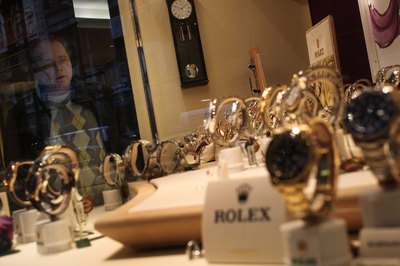 Man looking at Rolex watch display from shop window