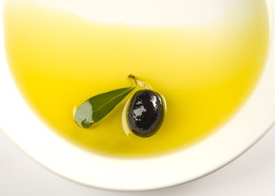 An olive in a bowl of olive oil.