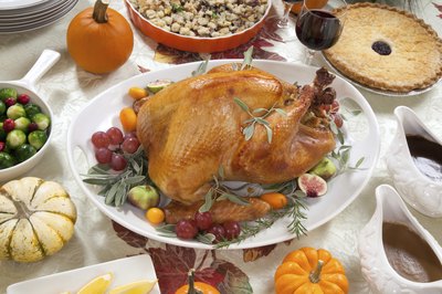 Roast turkey on dinner table with side dishes.