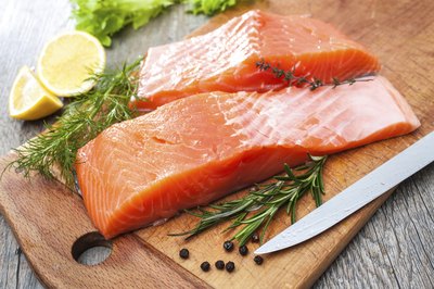 Raw salmon on cutting board.