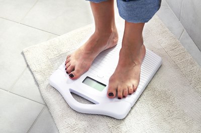 Feet standing on a bathroom scale.