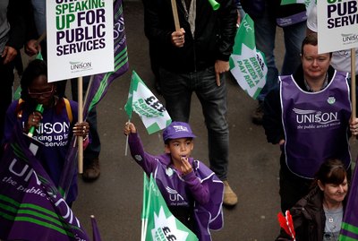A group of people on a protest march, holding up solo banners