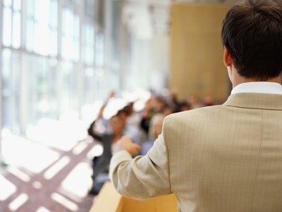 The back of a speaker at the podium during a seminar.