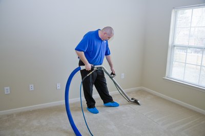 A professional cleans the carpets in a house.