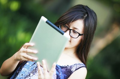 A young woman using her digital tablet outdoors.