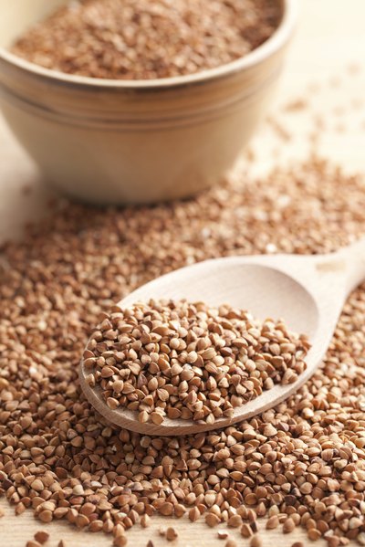 Dry buckwheat on wooden spoon