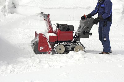 A man using a dual-stage snowblower