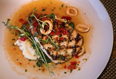 Grilled swordfish with calamari, spinach and potatoes.