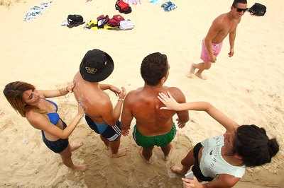 Guys having girls apply sunblock on Bondi Beach near Sydney, Australia