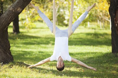 Man hanging upside down in park